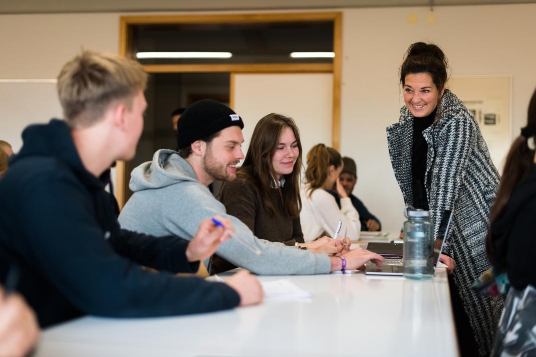 Studierende unterhalten sich mit einer Dozierenden.